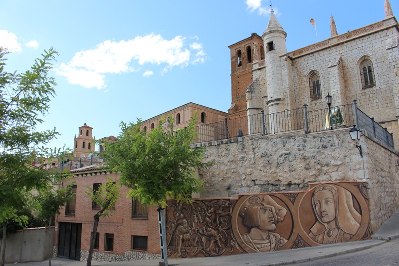 Carlos I y Juana "La Loca" retratados en la pared y, al fondo, la iglesia de San Antolín